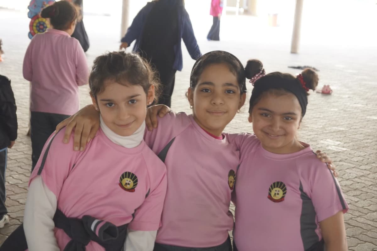 ثلاث طالبات يبتسمن خلال اليوم المدرسي